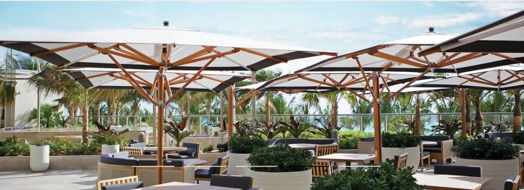 Wood-framed umbrellas across elevated resort dining deck